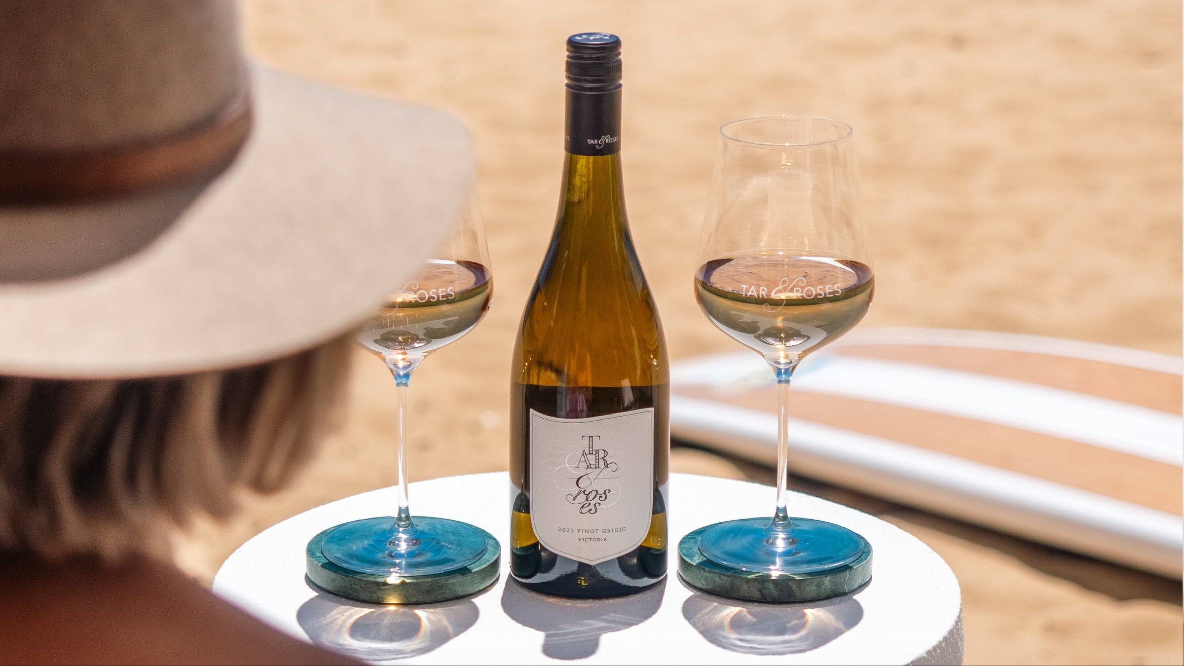 Wine bottle and glasses on a table with a beach background